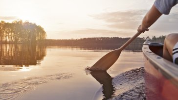 Woman canoeing at sunset in Manitoba